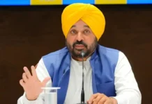 Punjab CM Bhagwant Mann Alleges Political Vendetta, Links Delhi Airport Fine to CEC’s Brother Punjab Chief Minister Bhagwant Mann addressing a press conference in Chandigarh with party flags in the background.